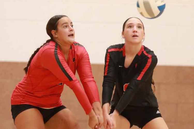 Seniors Kelli Rodriguez and Jo Lindsley team up to return a serve at Sacred Heart in Salina Sept. 16. The Bearcats defeated the Knights in the first two games, 25-18 and 25-15. KAREN BONAR/Ellsworth County Independent-Reporter