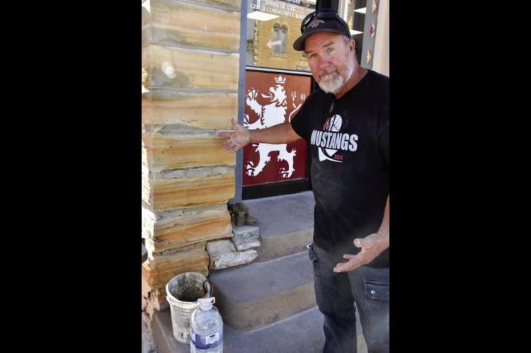 Jon Pancost, owner of Bluestem Quarry and Stone Works, Lucas, points out some of the concrete mortar his crew is replacing. CATHERINE DOUD/Ellsworth County Independent-Reporter