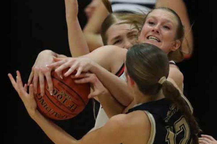 Ellsworth’s Alexis Moore scrambles for a rebound against Sacred Heart’s Nicole Richards. KAREN BONAR/Ellsworth County Independent-Reporter