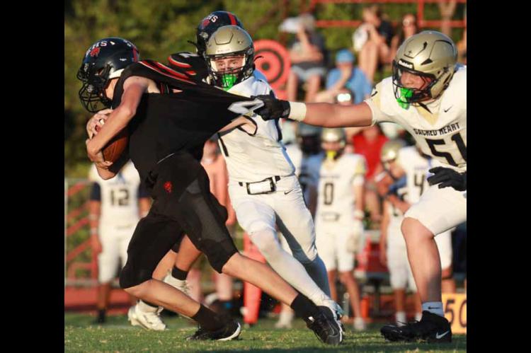 Ellsworth’s Gage Laas tries to grab a few more yards as Sacred Heart’s Landon Pfeifer grabs Laas’ jersey. The Bearcats lost the homecoming game 26-0. KAREN BONAR/Ellsworth County Independent-Reporter