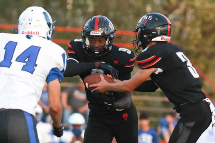 Senior Cooper McGowan is handed the ball from quarterback Carson Jacobs during the first half of the Homecoming game. The Bearcats defeated the Lions, 50-3. Photos by KAREN BONAR/Ellsworth County Independent-Reporter