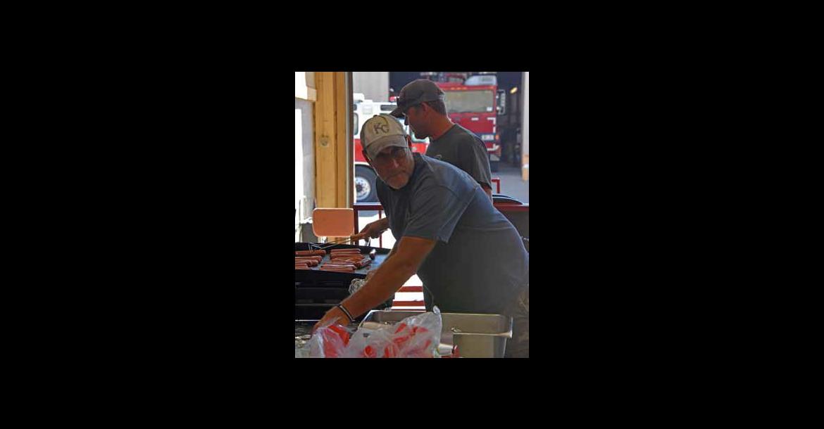 Second Assistant Chief Jeff Landon keeps the flattop filled with hot dogs for hungry guests. The freewill donation meal is an annual part of Fire Prevention Week.