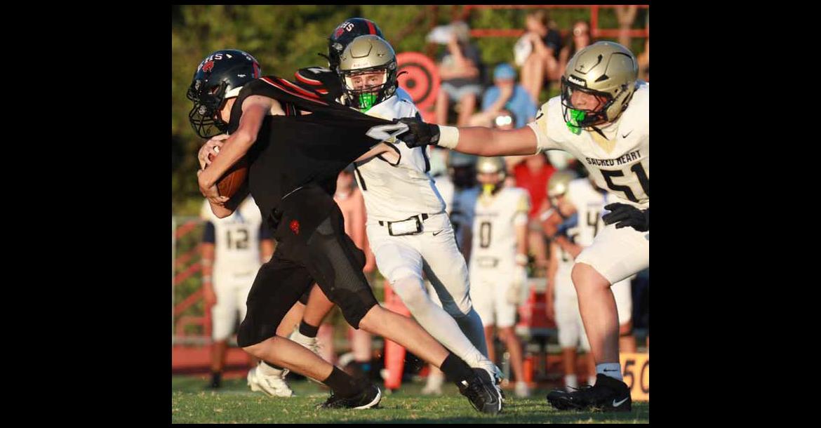 Ellsworth’s Gage Laas tries to grab a few more yards as Sacred Heart’s Landon Pfeifer grabs Laas’ jersey. The Bearcats lost the homecoming game 26-0. KAREN BONAR/Ellsworth County Independent-Reporter