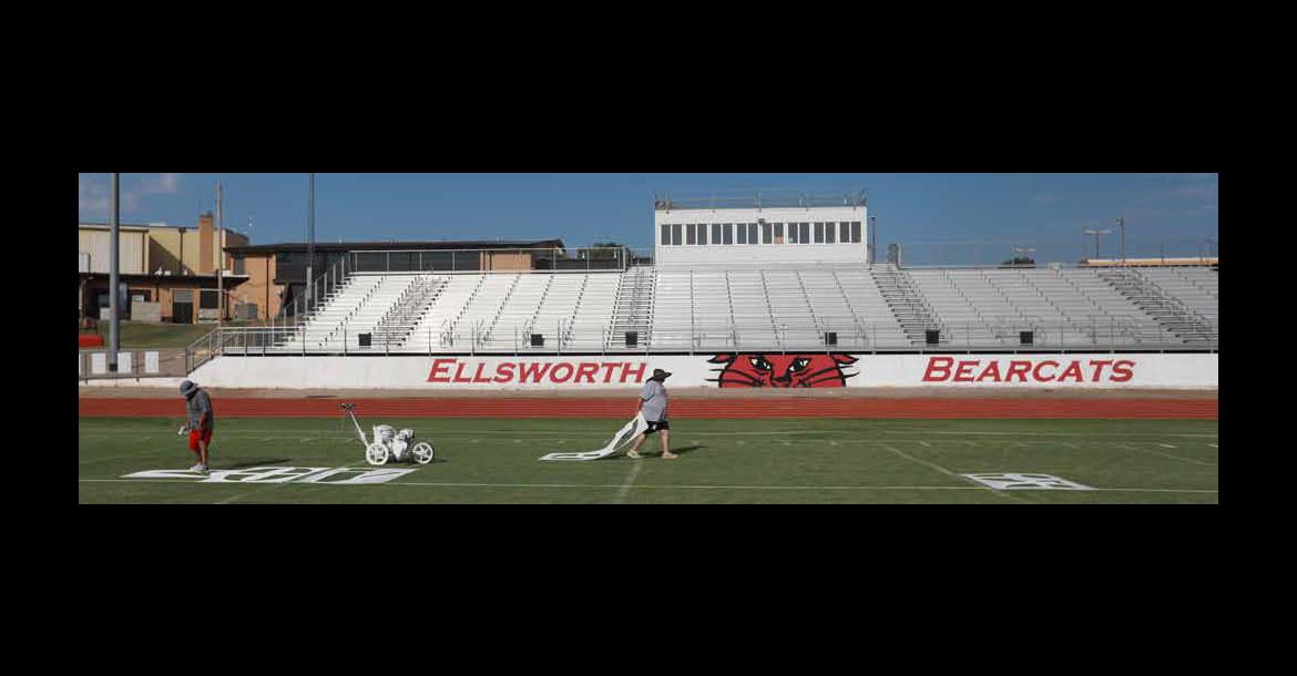 Celeste Rodriguez, left, examines her work, as Cindy Lloyd drags a stencil to the next 10-yard line marker Sept. 2 at Shanelec Field. The custodial workers paint the field before the football season begins, and maintains it throughout the season. Photos by KAREN BONAR/Ellsworth County Independent-Reporter