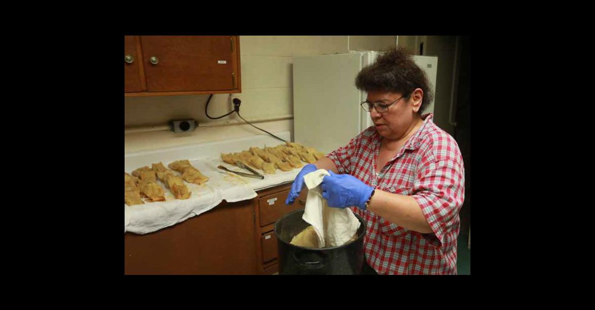 Phyllis Orozco unwraps tamales for take-out orders in advance of the annual fiesta at St. Ignatius of Loyola Church.