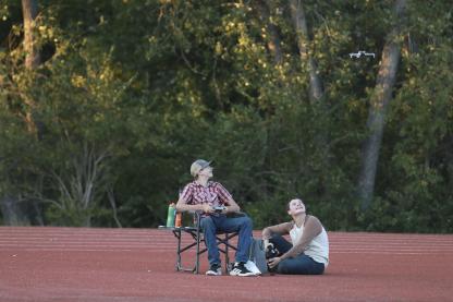Darren Kempke, left, and Brian McClendon watch the drone lift off the track near the end zone at Shanelec Field during the Sept. 4 football game.