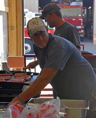 Second Assistant Chief Jeff Landon keeps the flattop filled with hot dogs for hungry guests. The freewill donation meal is an annual part of Fire Prevention Week.