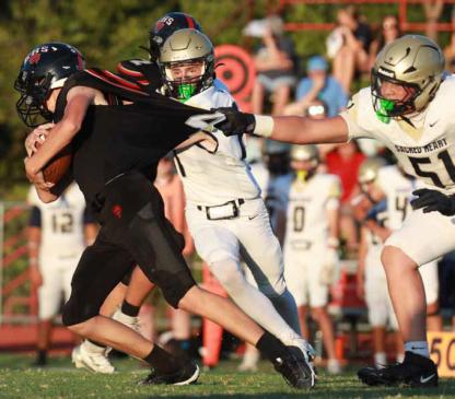 Ellsworth’s Gage Laas tries to grab a few more yards as Sacred Heart’s Landon Pfeifer grabs Laas’ jersey. The Bearcats lost the homecoming game 26-0. KAREN BONAR/Ellsworth County Independent-Reporter