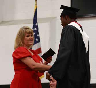 USD 327 Board President Gina McGowan hands her son, Cooper, his diploma during Sunday’s graduation ceremony. KAREN BONAR/Ellsworth County Independent-Reporter