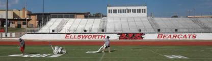 Celeste Rodriguez, left, examines her work, as Cindy Lloyd drags a stencil to the next 10-yard line marker Sept. 2 at Shanelec Field. The custodial workers paint the field before the football season begins, and maintains it throughout the season. Photos by KAREN BONAR/Ellsworth County Independent-Reporter