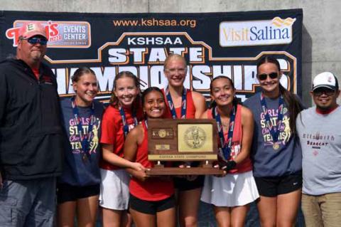 The Ellsworth girls’ tennis team celebrates with the state championship trophy. Pictured, from left, are head coach Eric Anderson, Makenna Anderson, Reygan Coonrod, Felis De La Cruz, Hannah Vague, Inarie Rippert, Karli Haase and assistant coach Jason Ma